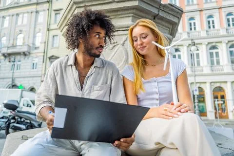 Two engineering students review notes on wind energy and the girl holds a s.. Stock Photos
