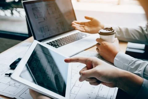 Two engineering working together and using digital tablet looking blueprint.. Foto stock