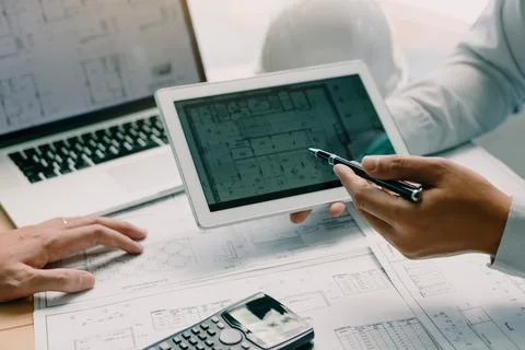 Two engineering working together and using digital tablet looking blueprint.. Stock-Fotos