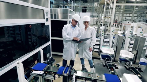 Two engineers are controlling manufacturing of solar cells Stock Footage 166568093