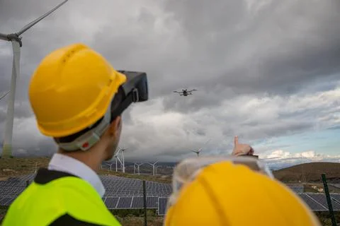 Two engineers are flying a drone at a solar power plant, sustainable and cl.. Foto stock