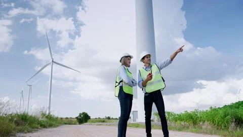 Two engineers are standing together discussing wind power projects and work Stock Footage 165046538