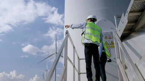 Two engineers are standing together discussing wind power projects and work Stock-Footage 165065347