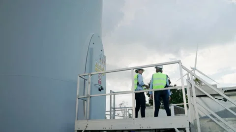 Two engineers are standing together discussing wind power projects Stock Footage 165442901