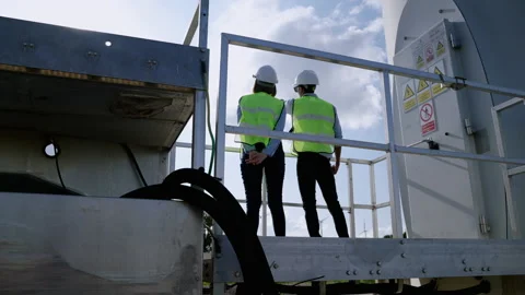Two engineers are standing together discussing wind power projects and work Stock-Footage 165948314