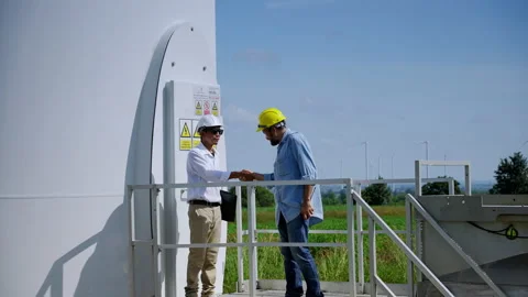 Two engineers are standing together discussing wind power projects and work Stock Footage 167148093