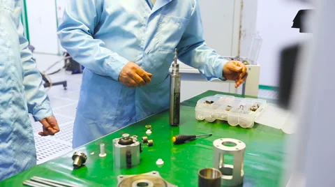 Two Engineers Are Testing the Device on a Green Table Uniform Tech Lab Stock Footage 60576892