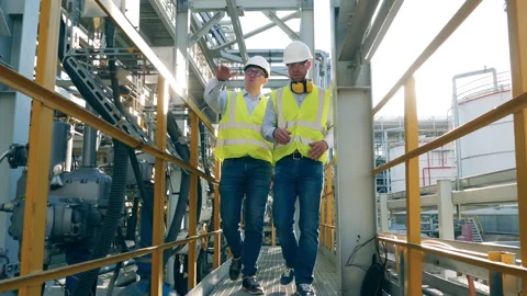 Two engineers are walking along the oil refinery plant Stock Footage 156739450