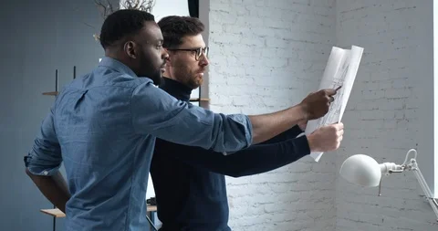 Two Engineers checking their Blueprints, looking concentrated in Office Stock Footage 126162415