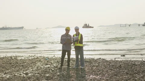 Two engineers collaborate on an environmental assessment at a coastal Stock Footage 335699351