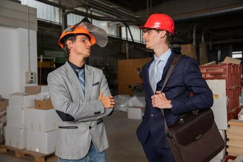 Two engineers at the construction site discuss the work to be done, colleag.. Stock Photos