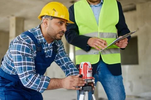 Two engineers on the construction use working equipment. Stock Photos