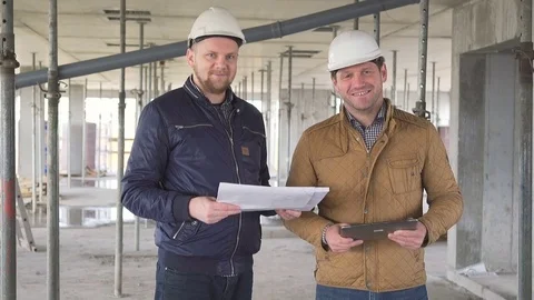 Two engineers consulting building project and smiling to camera. Vídeos de archivo 72358935