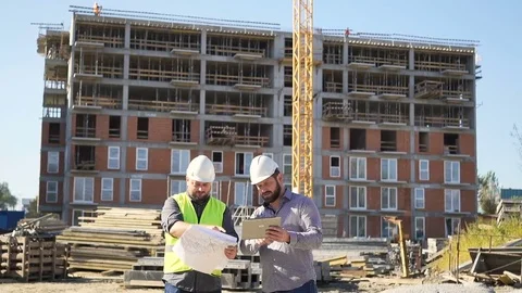 Two engineers consultng building project with data on tablet. Slider shot. Vidéo 70785085