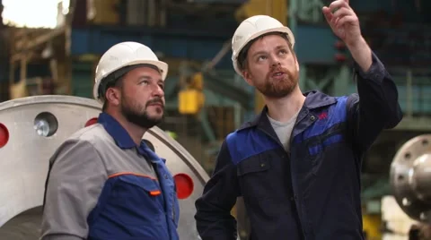 Two engineers discuss important stages of construction in heavy industry factory Stock Footage 65403922