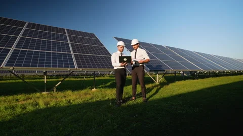 Two Engineers Discuss Solar Panel Performance on Site Stock Footage 296849207