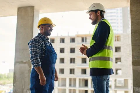 Two engineers discuss work related questions together. Stock Photos