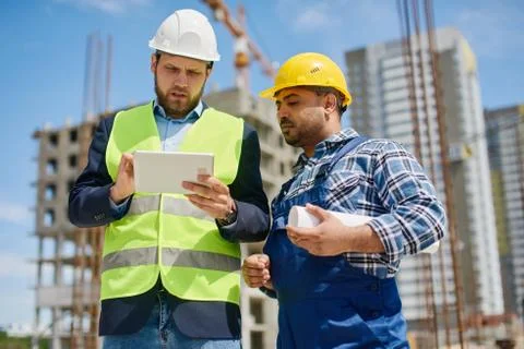 Two engineers discuss work related questions together. Stock Photos