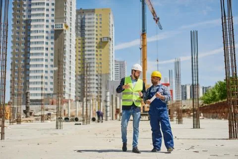 Two engineers discuss work related questions together. Stock Photos