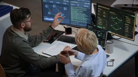 Two Engineers Discussing Network System on Computers in Cybersecurity Office Stock Footage 334935089
