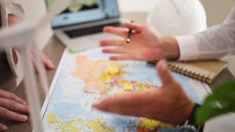 Two engineers discussing a new renewable energy project, pointing at a worl.. Stock Footage 346173249