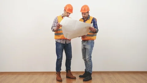The two engineers with a drawing discuss on the white background Stock-Footage 90166406