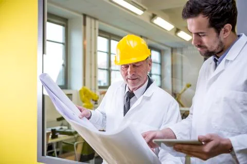 Two engineers in factory looking at plan Stock Photos