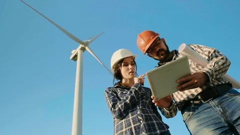 Two engineers in a field are discussing while looking at the tablet. The wind Stock Footage 96843639