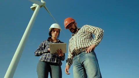 Two engineers in a field think about information from tablet, suggesting Stock Footage 96843390