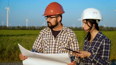 Two engineers in a field view plan and compare it with infornation on tablet Video stock 96843865