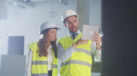 Two Engineers in Hard Hat are using Tablet Computer of Augmented Reality. Stock Footage