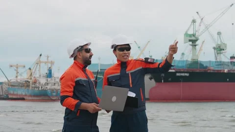 Two engineers in hard hats stand by the water Stockbeeldmateriaal 343333461