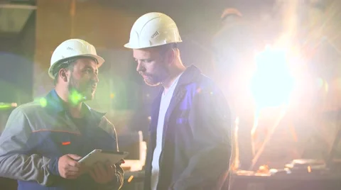 Two engineers in hardhats discussing in front of welding process Stock Footage 64796259