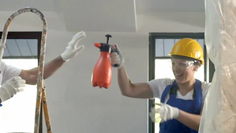 Two engineers in hardhats having fun while working at the construction site of Vídeos de archivo 91236717