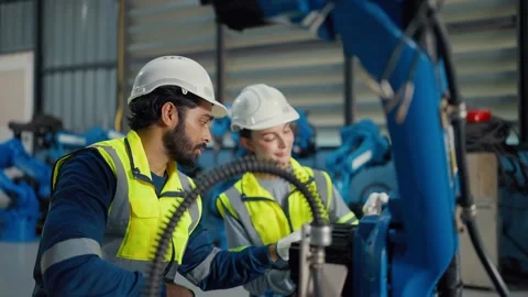 Two engineers inspect robotic arm in factory Video stock 340986516