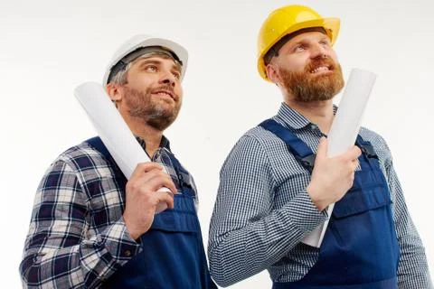 Two engineers look up on a white background. Stock Photos