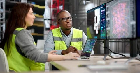 Two Engineers, A Man And Woman, Discuss Rocket Engine Designs On A Big Comput Stock Photos