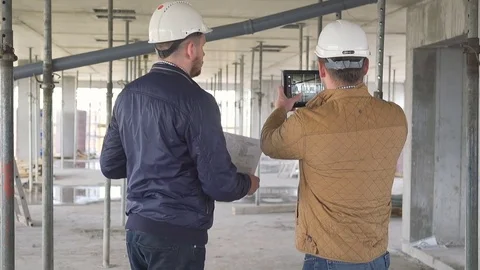 Two engineers meet at builiding and make photo of construction work. 库存影片 72358845