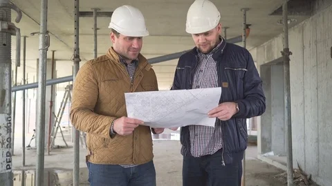 Two engineers meet at construction and consult building project. 库存影片 72358525