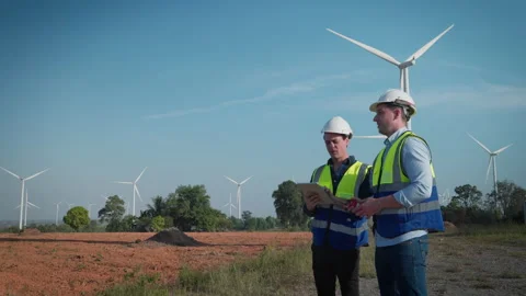 Two engineers men working at wind turbine farm. Stock Footage 228995747
