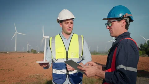 Two engineers men working at wind turbine farm. Stock Footage 229148200