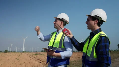 Two engineers men working at wind turbine farm. Stock Footage 229169763