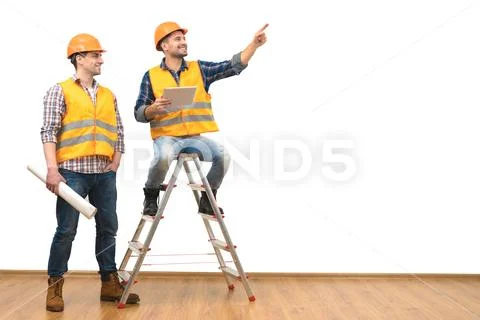 The two engineers near the ladder gesture on the white wall background Stock Photos