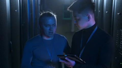 Two engineers or programmers talking and working with device while standing in Stock Footage 166837278