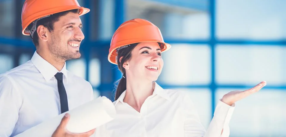 The two engineers with a paper gesture on the background of the building Fotos de archivo