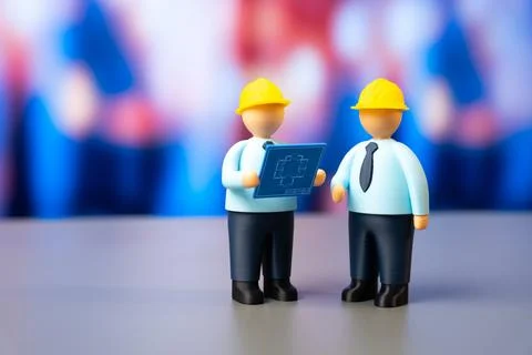 Two engineers with plans and wearing yellow hard hats. Development and design 스톡 사진