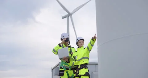 Two engineers in reflective uniform discussing wind turbine maintenance plan Video stock 335210007