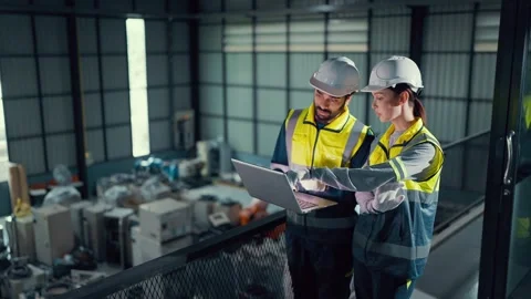 Two engineers review data on a laptop Video stock 340986575