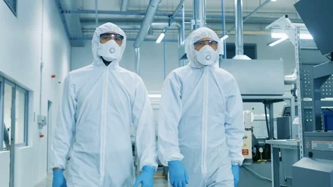 Two Engineers/ Scientists in Hazmat Sterile Suits Walking Through Factory. Stock Footage