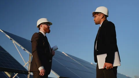 Two engineers shaking hands in front of a solar panel farm Stock Footage 314407835